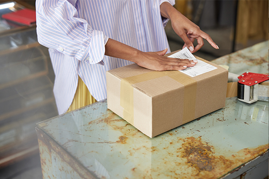 Paketschein wird auf Paket geklebt