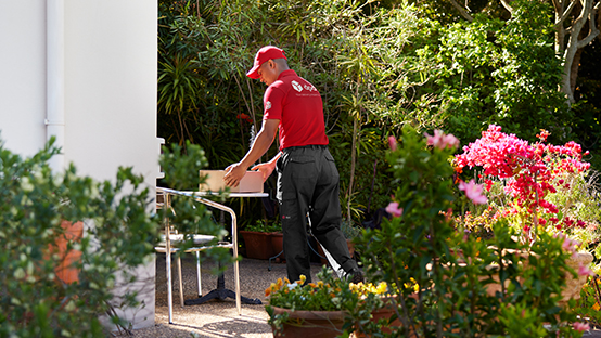 driver deposites a parcel at a confirmed save space in the garden