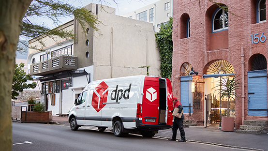dpd driver delivering parcels and van in front of a building