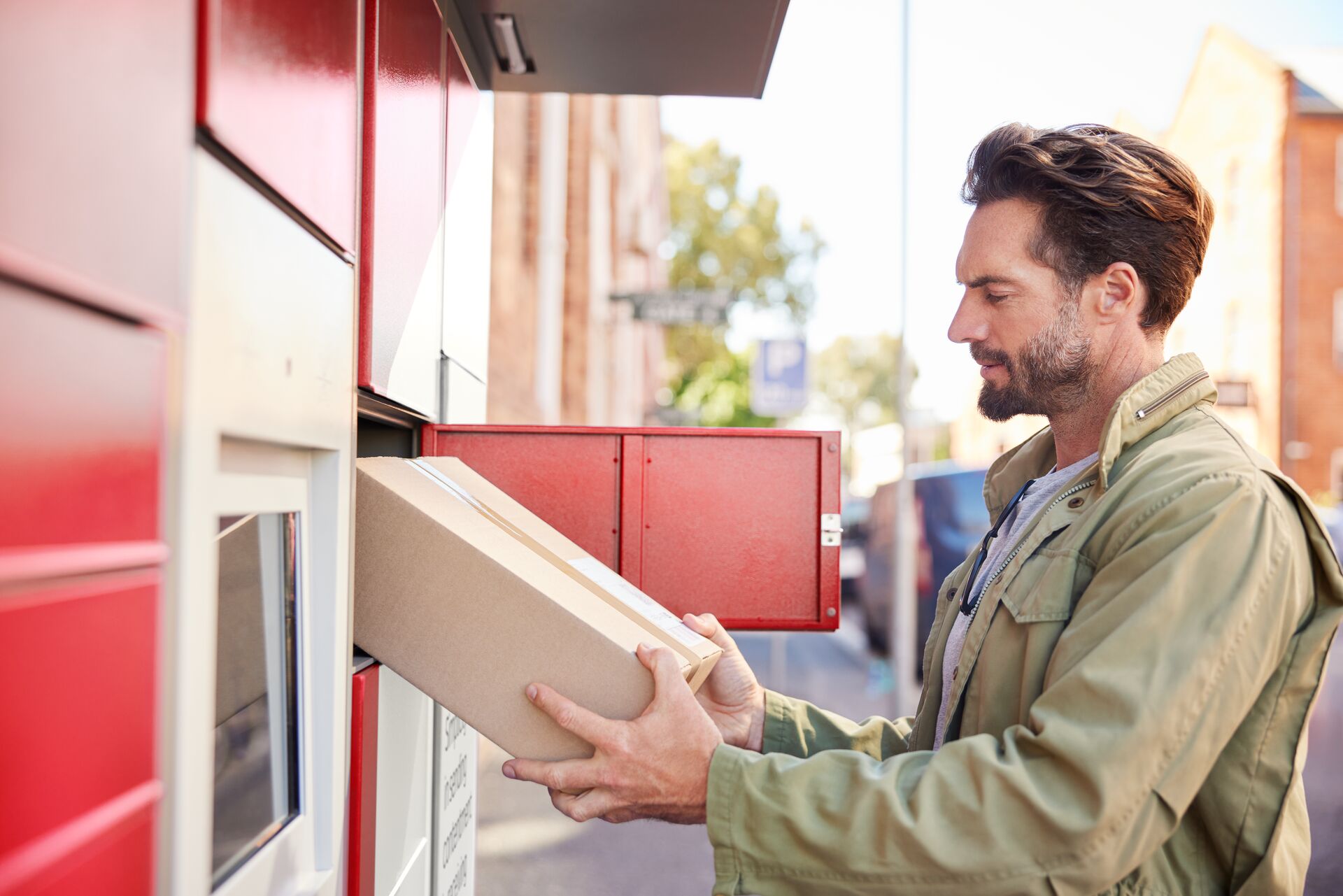 Paketempfänger nimmt ein Paket aus einer Pickup Paketstation