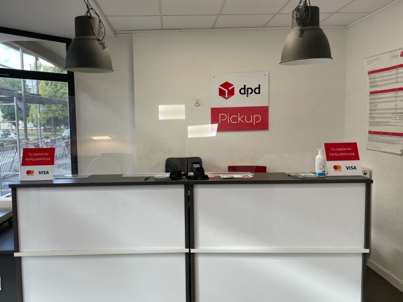 Punkt DPD Pickup: biała lada z logo, szyba ochronna i informacja o płatności kartą.