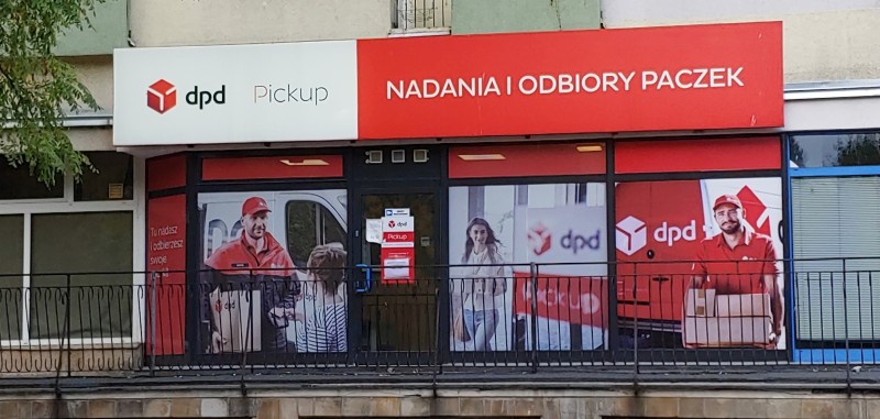 Punkt DPD Pickup: nadania i odbiory paczek. Kurier z paczką na witrynie.