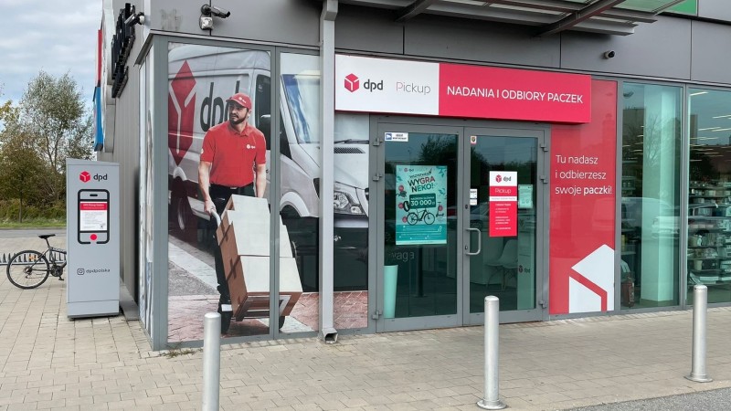 Punkt DPD Pickup: nadawanie i odbiór paczek. Kurier z paczkami na witrynie.