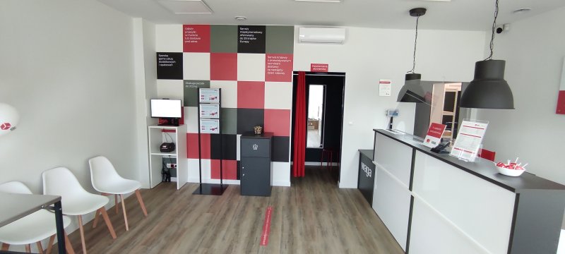 Wnętrze punktu DPD: lada, krzesła, ściana z informacjami o usłudze.