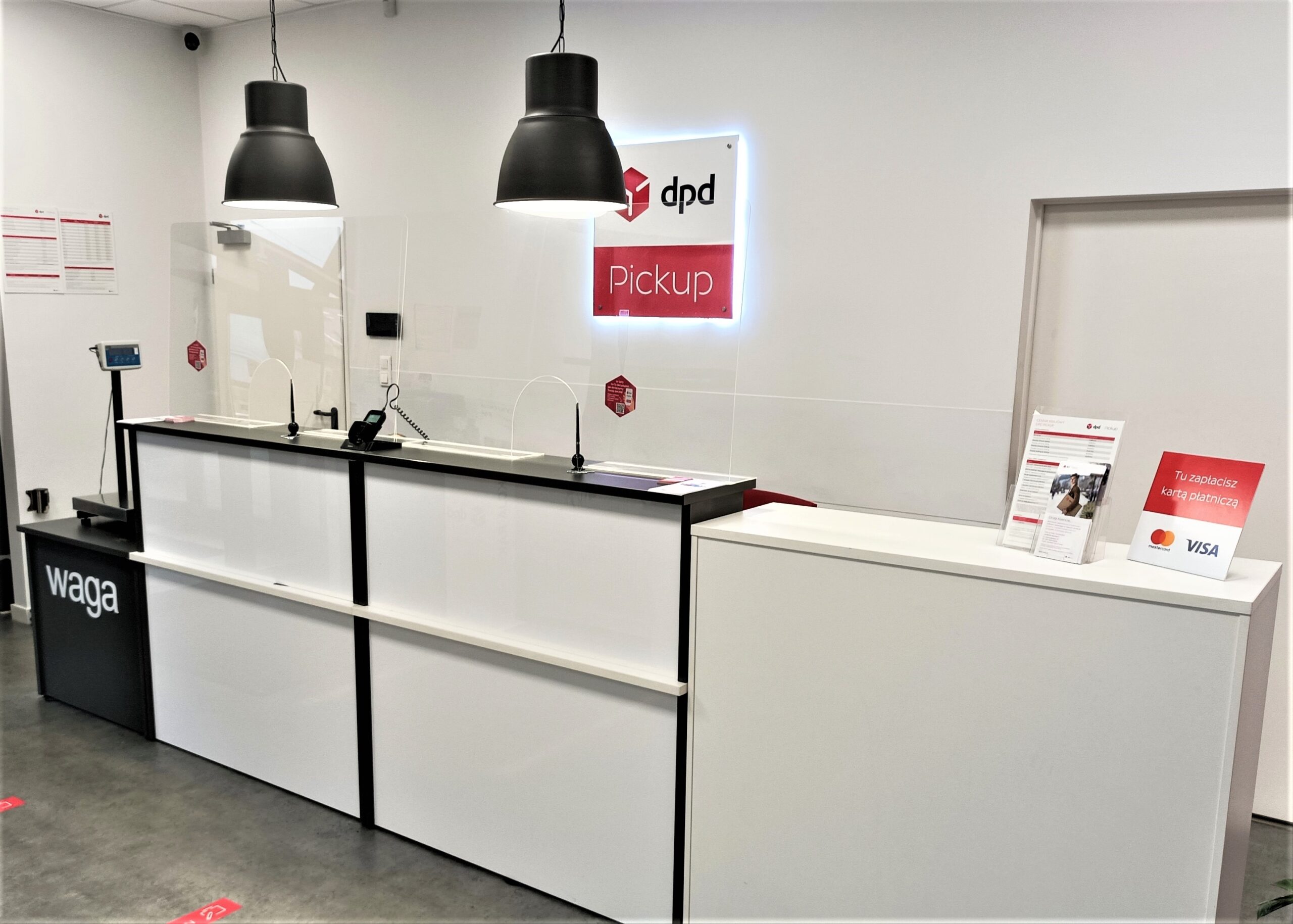 Punkt DPD Pickup: białe lady z logo, waga paczek i informacja o płatności kartą.