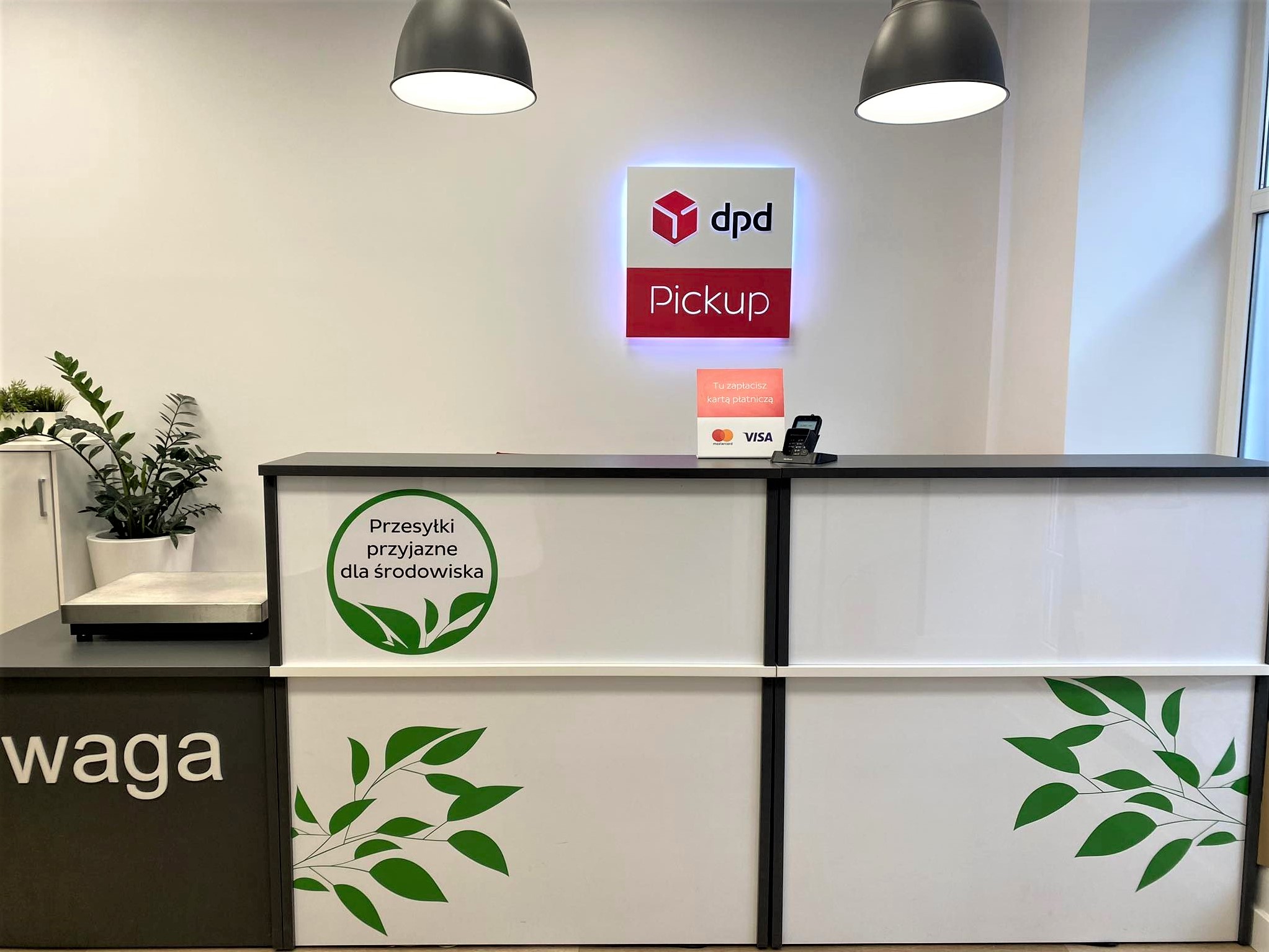 Punkt DPD Pickup: lada z logo, waga paczek, informacja o płatności kartą.