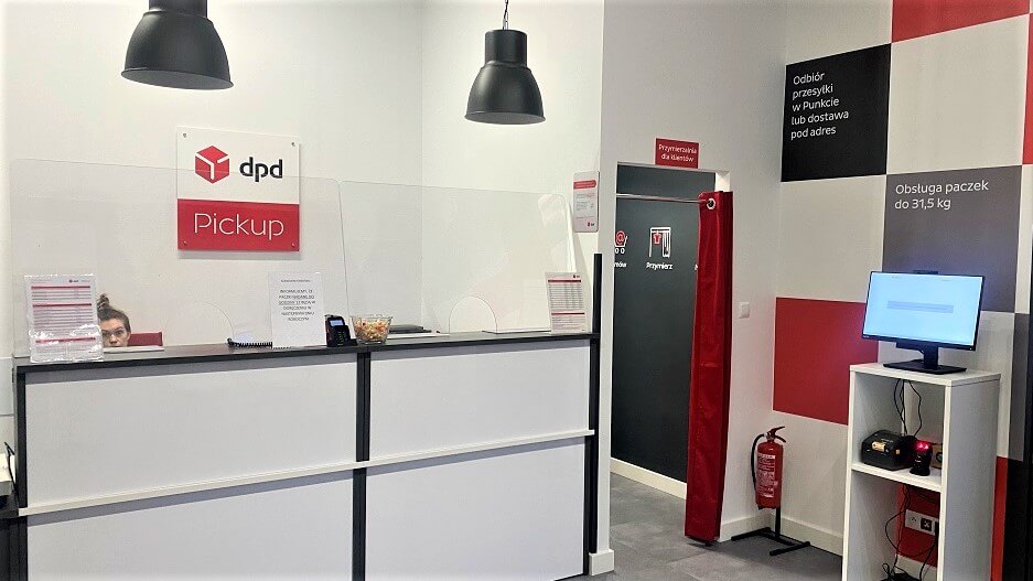 Punkt DPD Pickup: obsługa klienta za ladą, przymierzalnia, stanowisko komputerowe.