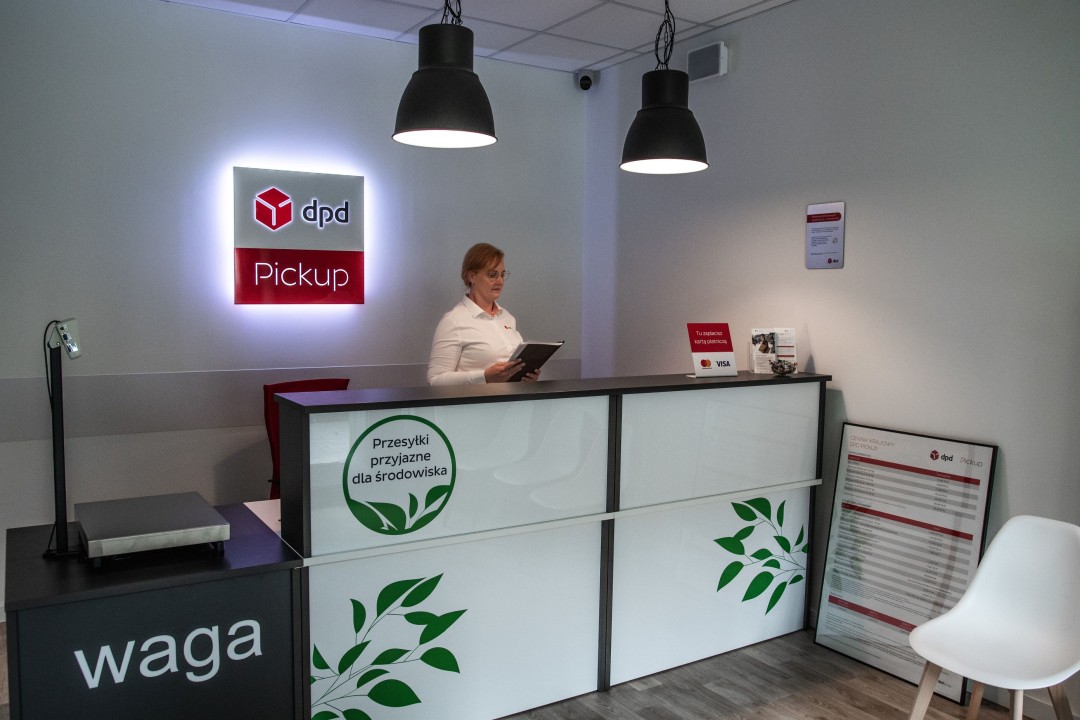 Punkt DPD Pickup: pracownik za ladą, logo DPD, waga paczek.