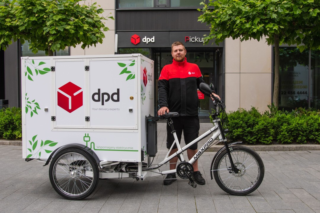 Kurier DPD z rowerem cargo przed punktem Pickup. Ekologiczny transport.