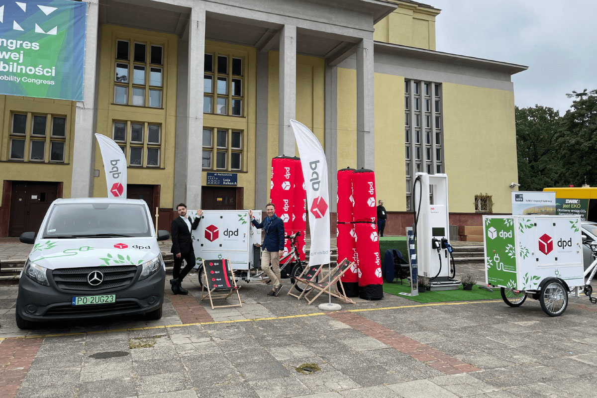 Ekologiczny transport DPD: samochód elektryczny, rower cargo, stacja ładowania.