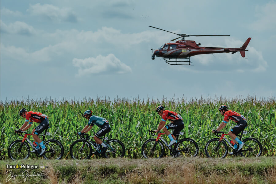 Kolarze podczas wyścigu Tour de Pologne, nad nimi helikopter.