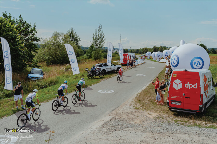 Kolarze podczas Tour de Pologne, w tle samochód DPD i kibice.