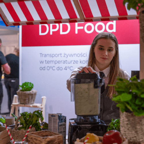 Kobieta robiąca koktajl w blenderze przy stoisku DPD Food podczas wydarzenia Gastrotargi.