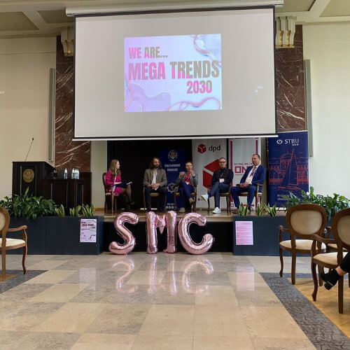 Panel dyskusyjny na XIV Studenckiej Konferencji Morskiej, z prelegentami siedzącymi na scenie i napisem "MEGA TRENDS 2030" na ekranie.