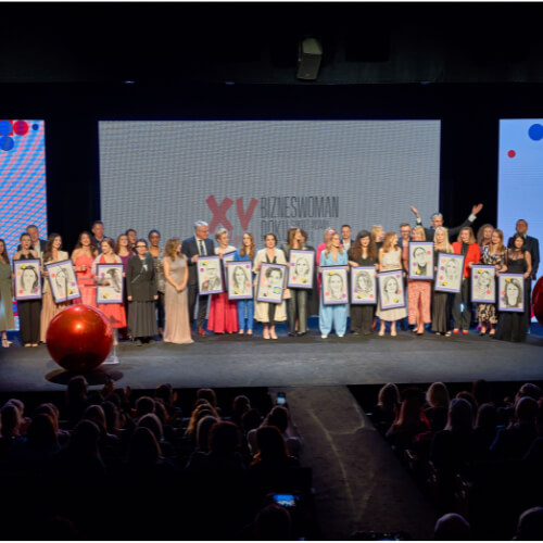 Gala Bizneswoman Roku, laureatki z portretami na scenie.