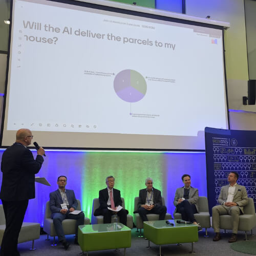 Panel dyskusyjny na konferencji Green Cities, w którym udział bierze przedstawiciel DPD Polska. Na ekranie wyświetlone jest pytanie "Will the AI deliver the parcels to my house?", a uczestnicy panelu siedzą na scenie.