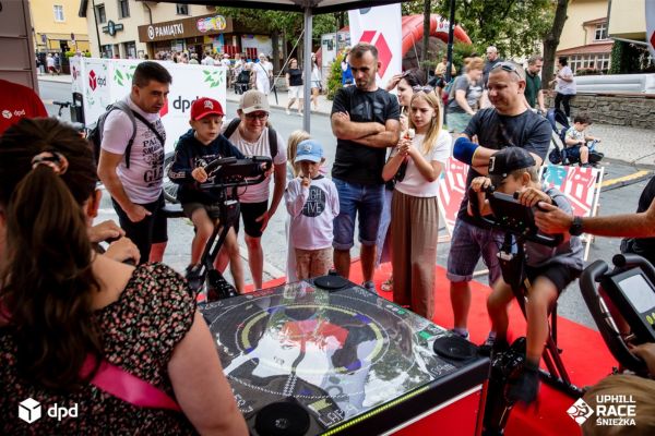 Rodziny z dziećmi biorące udział w interaktywnej grze edukacyjnej na stoisku DPD Polska podczas wyścigu Uphill Race w Karpaczu.