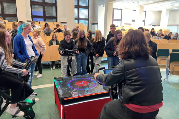 Grupa uczniów testuje interaktywną stację rowerową DPD, zaprojektowaną do edukacji o ekologii i aktywnym stylu życia, podczas Dolnośląskiego Festiwalu Nauki.