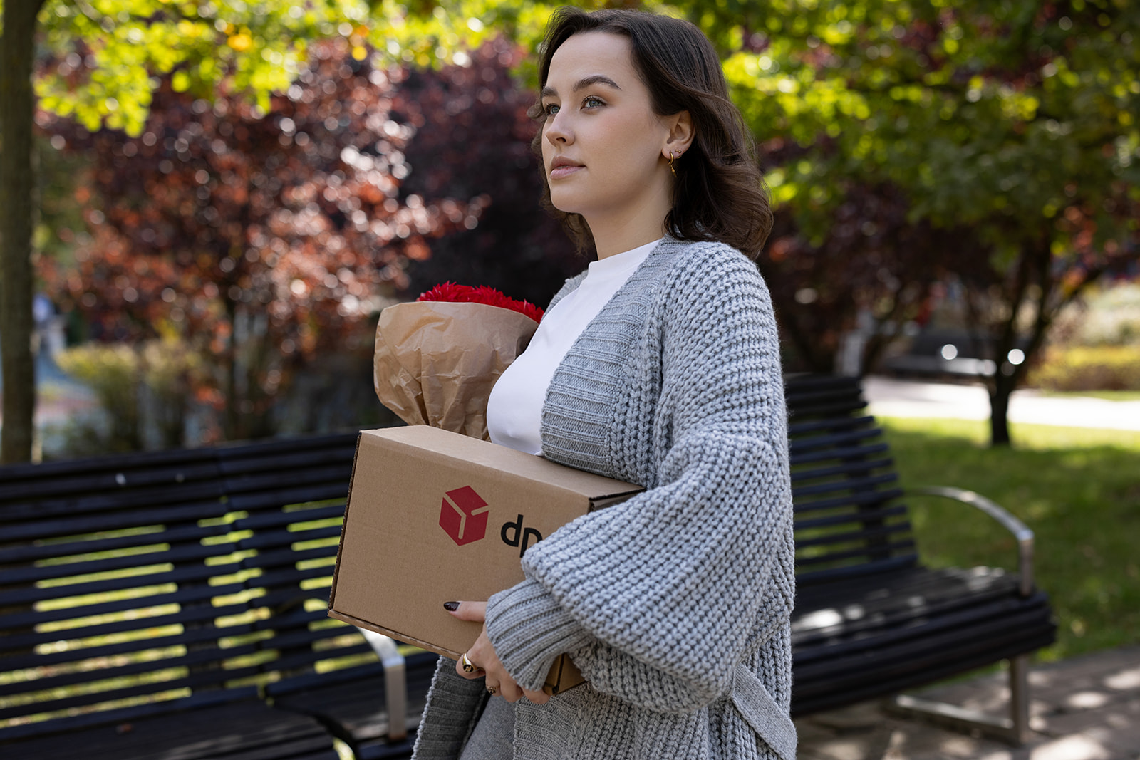 DPD Pickup klientka niesie paczkę w parku
