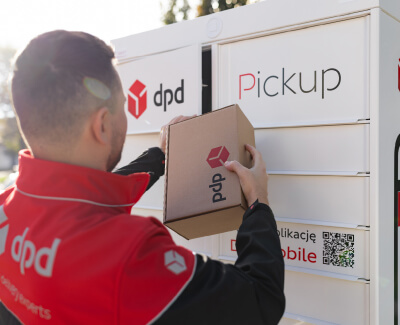Kurier DPD wkłada paczkę z logo DPD do białego automatu paczkowego DPD Pickup
