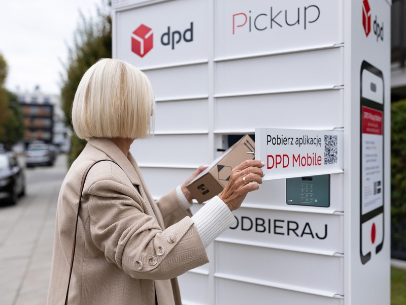 Kobieta odbiera przesyłkę z białego automatu paczkowego DPD