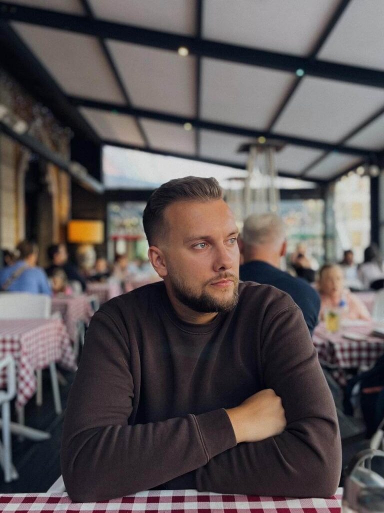 Jan Jucha siedzi przy stole z założonymi rękami