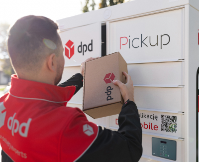 Kurier DPD wkłada paczkę z logo DPD do białego automatu paczkowego DPD Pickup