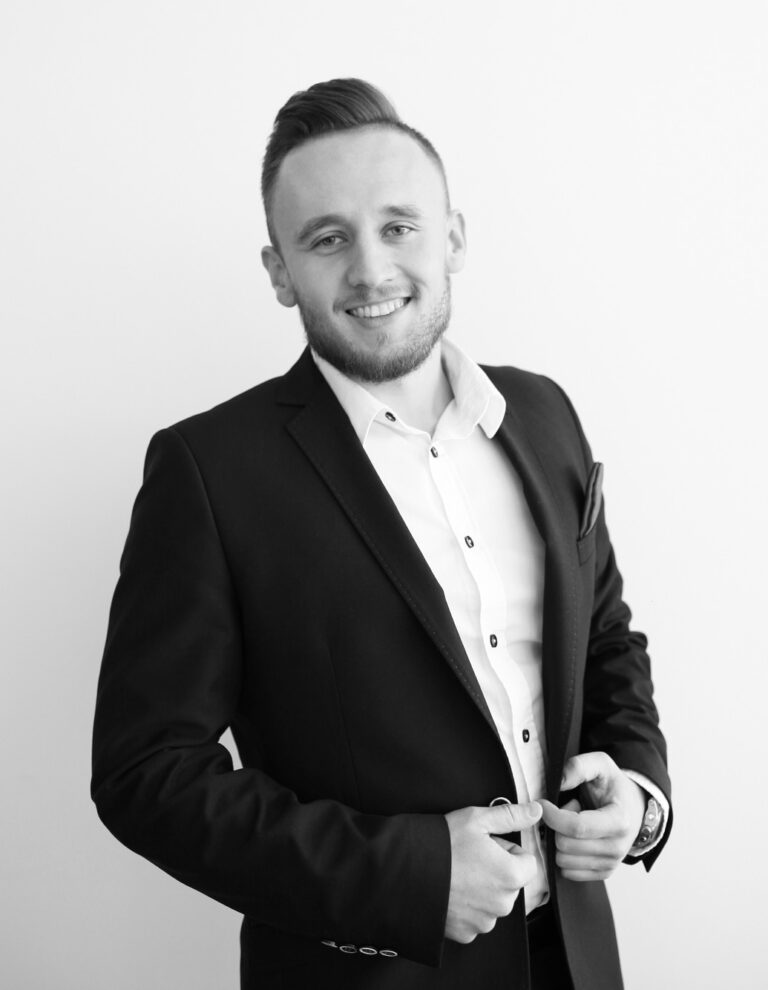 Czarnobiałe zdjęcie uśmiechniętego mężczyzny w garniturze