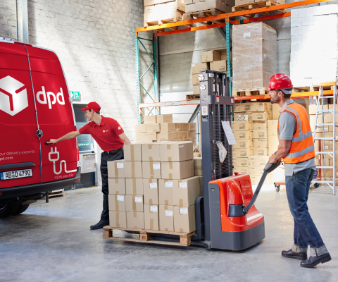 Magazyn, paczki na palecie są wiezione na paleciaku do furgonetki DPD