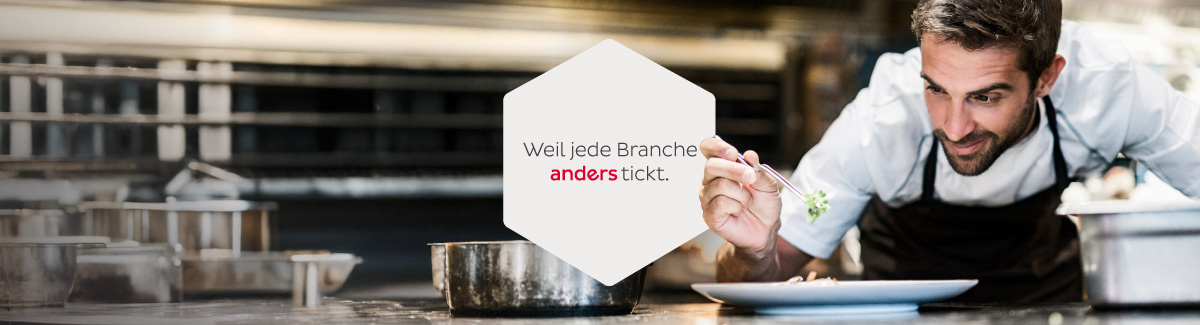 Koch serviert Lebensmittel auf den Teller in einer Küche